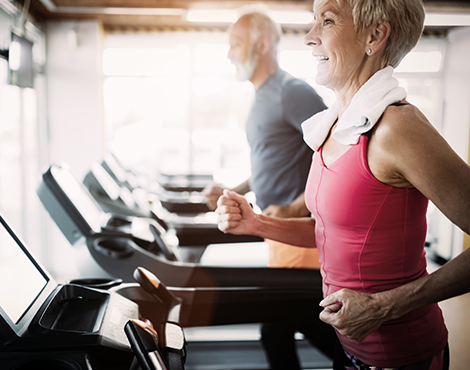 Woman with her husband, running on treadmills for exercise
